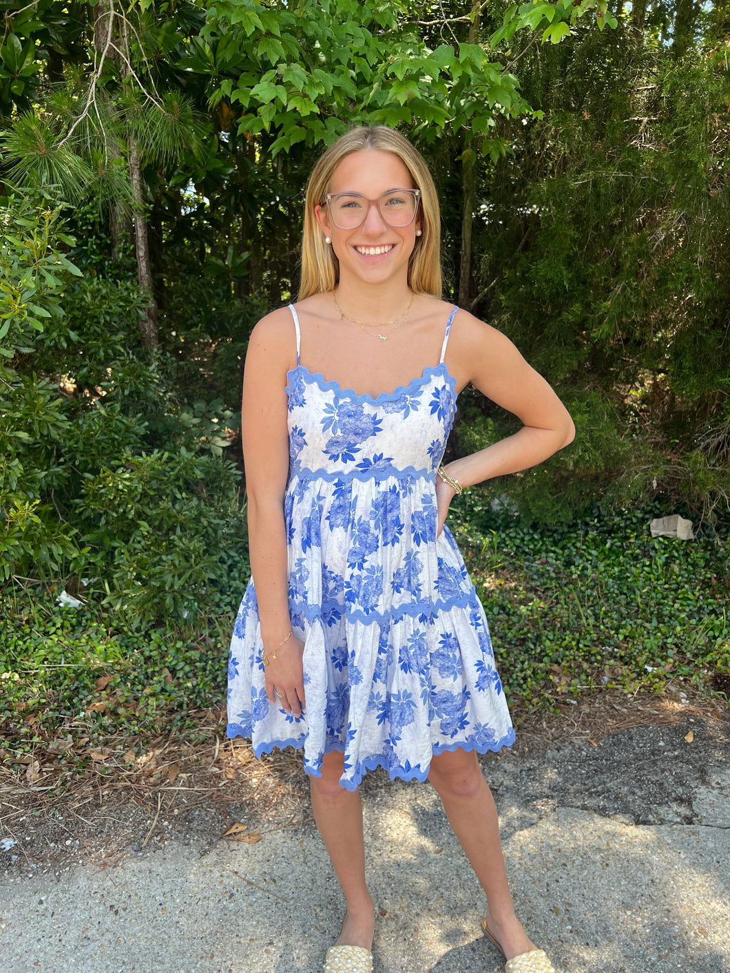 D23496 Floral print v-neck spaghetti strap mini dress featuring ric rac trim. Smocking at back. Adjustable straps.