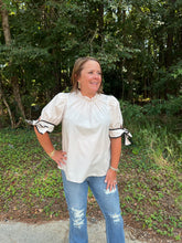 Load image into Gallery viewer, T24241 Solid mock neck short sleeve top featuring ruffled neckline. Self-tie bow detail at cuff. Button closure at back