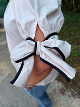 Load image into Gallery viewer, T24241 Solid mock neck short sleeve top featuring ruffled neckline. Self-tie bow detail at cuff. Button closure at back