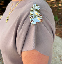 Load image into Gallery viewer, Solid cap sleeve top featuring metal flower accent at shoulder