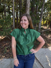 Load image into Gallery viewer, Solid cap sleeve top with a ruffled high neckline. Hidden buttons at front.